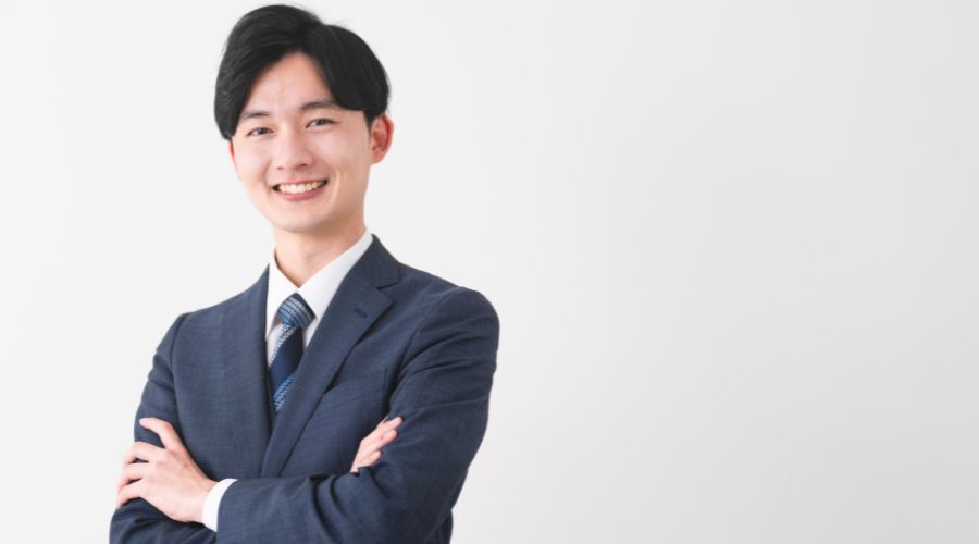 笑顔で腕を組む男性