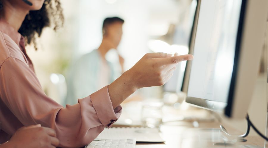 画面を指さして指示する女性