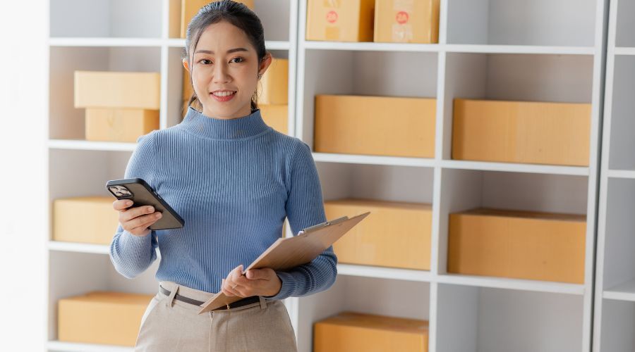 バインダーとスマホを持った女性