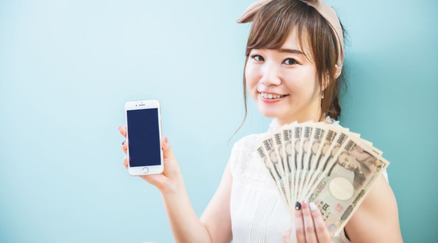 スマホとお金を持った女性