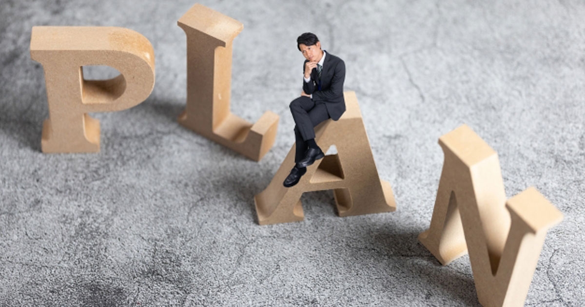 PLANの文字と考えている男性