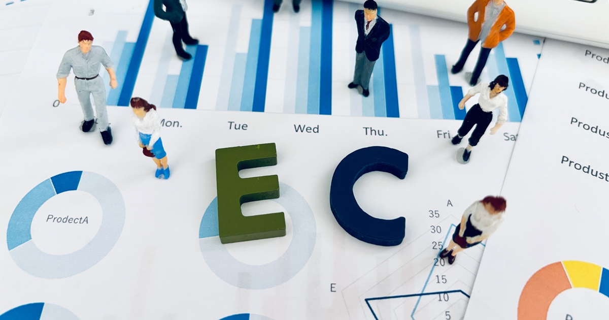 ECの文字を囲む7体の人形