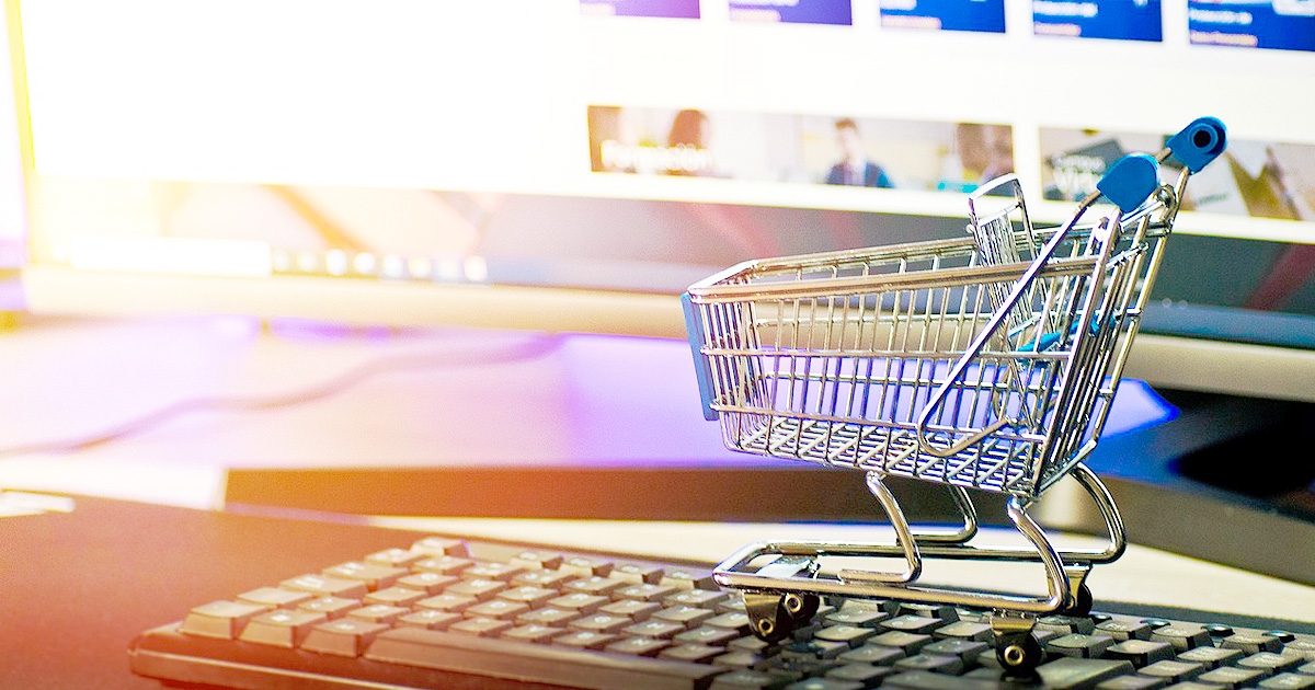 キーボードの上に置かれたショッピングカートのミニチュア