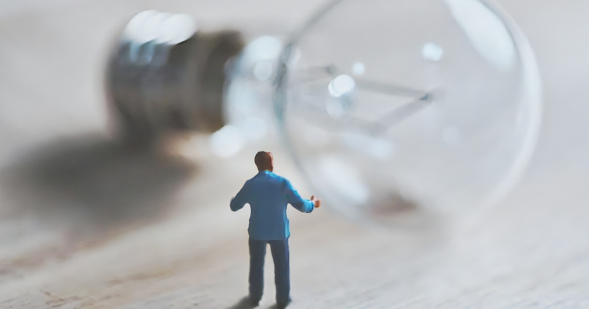 電球の前に立つ男性のミニチュア