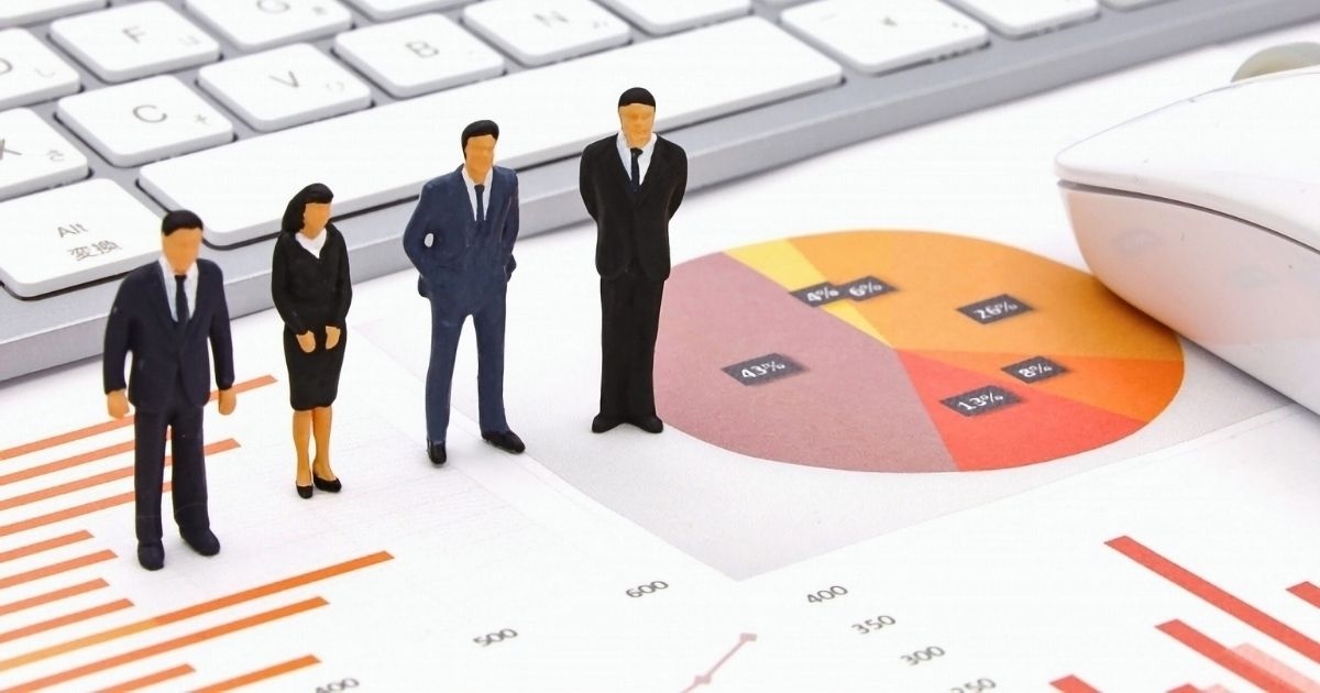 グラフを眺めるミニチュアの人々